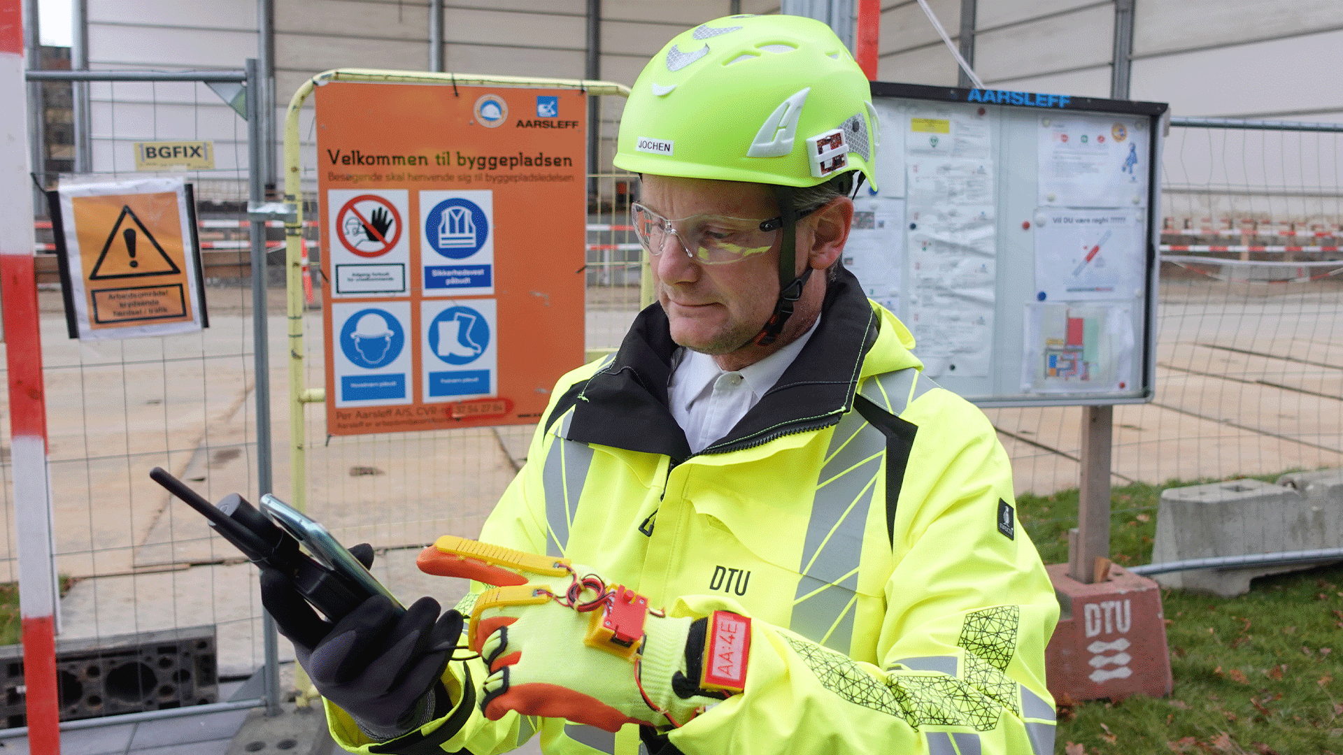 Man in a high vis jacket and hard hat by a construction site. Photo: Olga Golovina